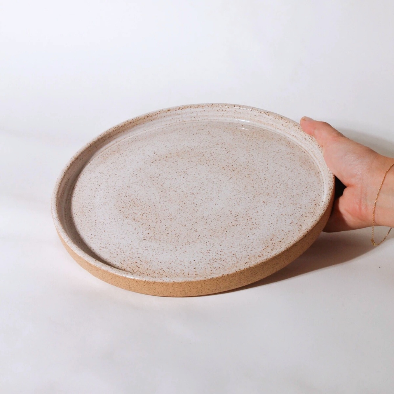 Prato Reto de cerâmica Esmo com bordas verticais, acabamento salpicado e base em argila natural Esmo.